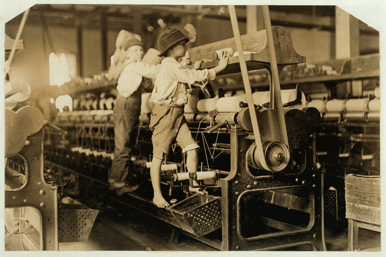 Meninos pequenos subindo no quadro de fiação para consertar fios quebrados e substituir bobinas vazias em Bibb Mill, Macon, Geórgia, 1909 de Lewis Wickes Hine