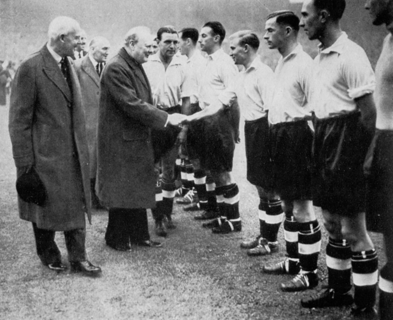 Winston Churchill cumprimenta o time de futebol da Inglaterra, Wembley, Londres, em outubro de 1941. de London News Agency