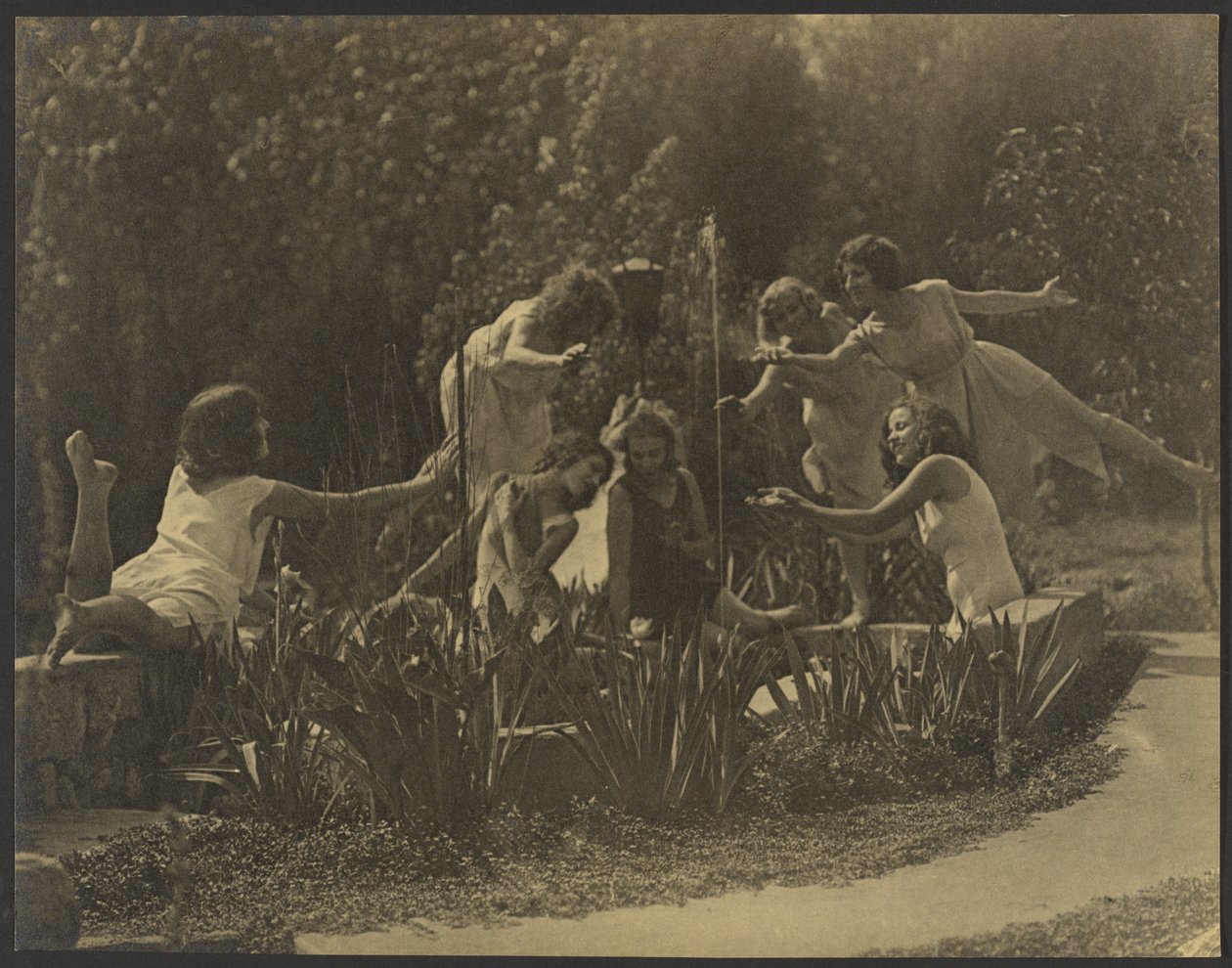 [Bailarinos posam junto ao muro do jardim] de Louis Fleckenstein