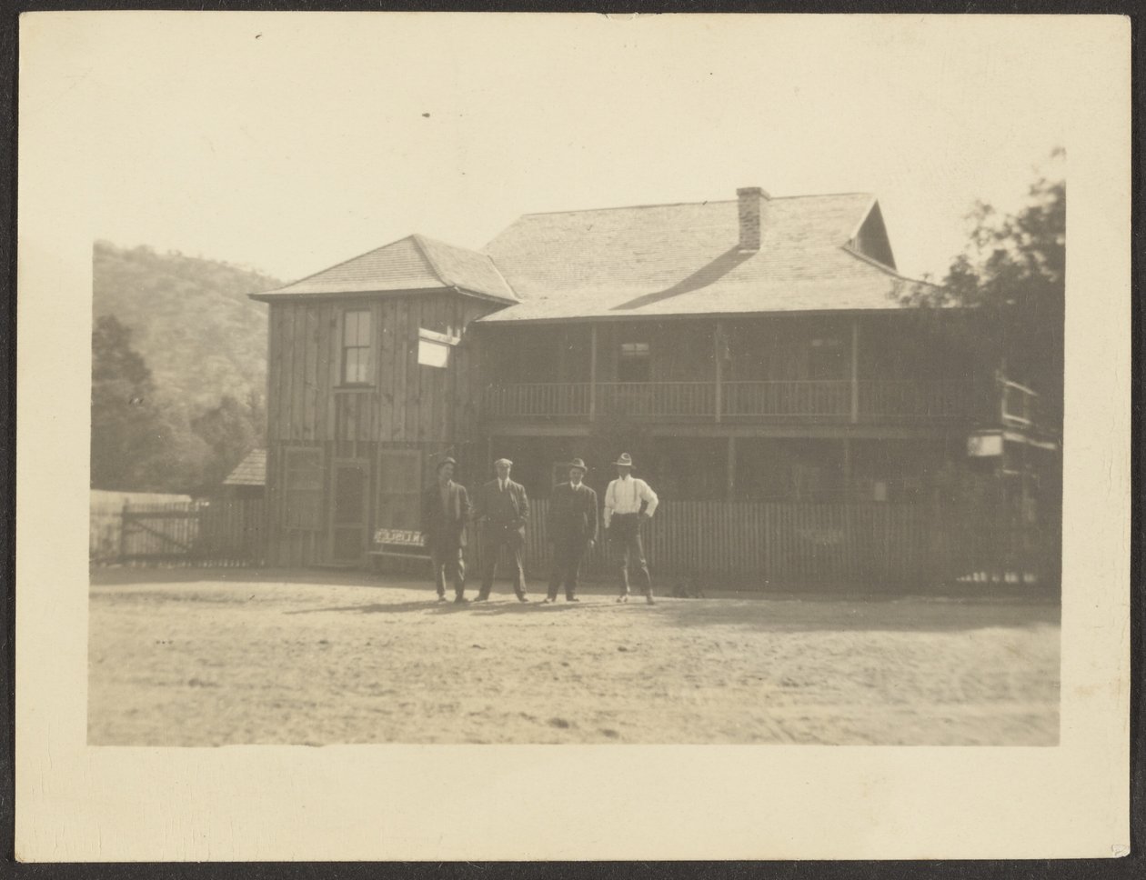 [Quatro homens diante de um edifício de madeira]. de Louis Fleckenstein