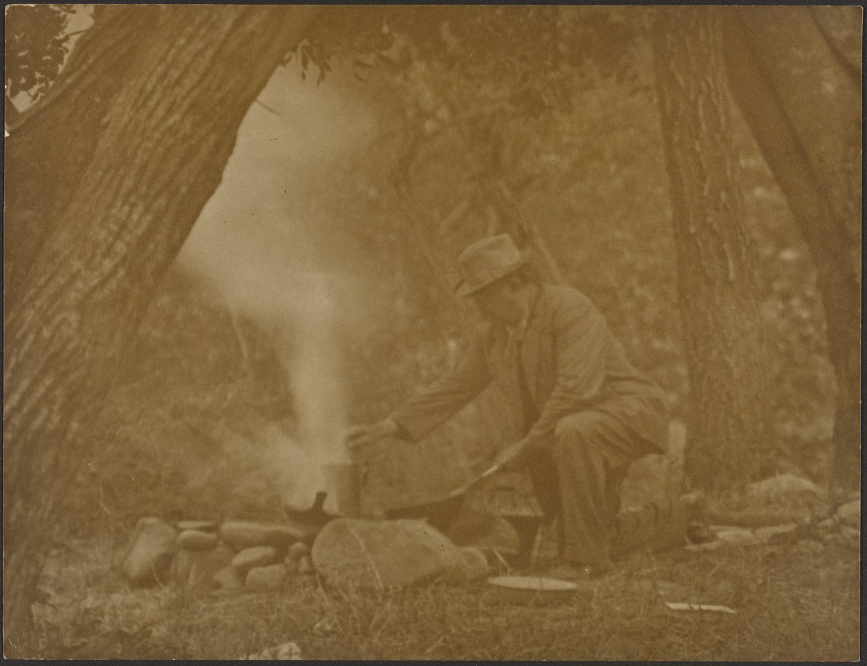 [Homem a cozinhar numa fogueira de acampamento na floresta] de Louis Fleckenstein