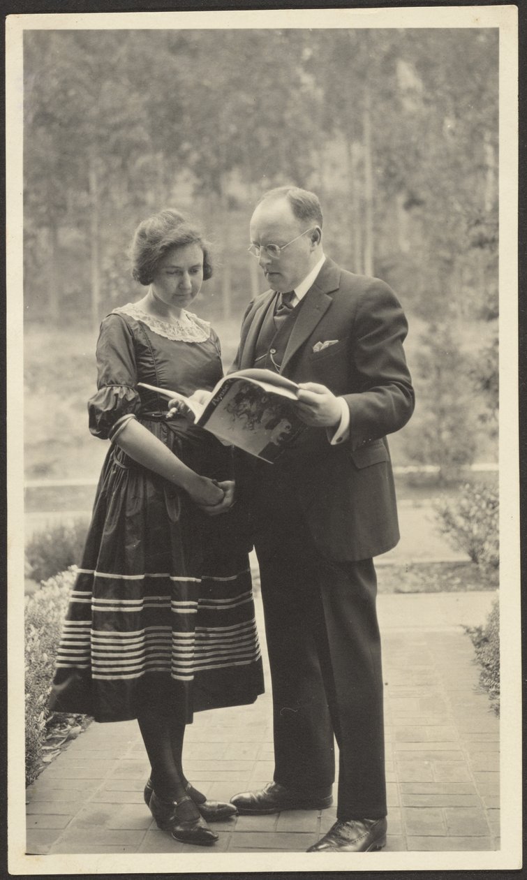 [Homem e mulher de pé no exterior com uma revista] de Louis Fleckenstein