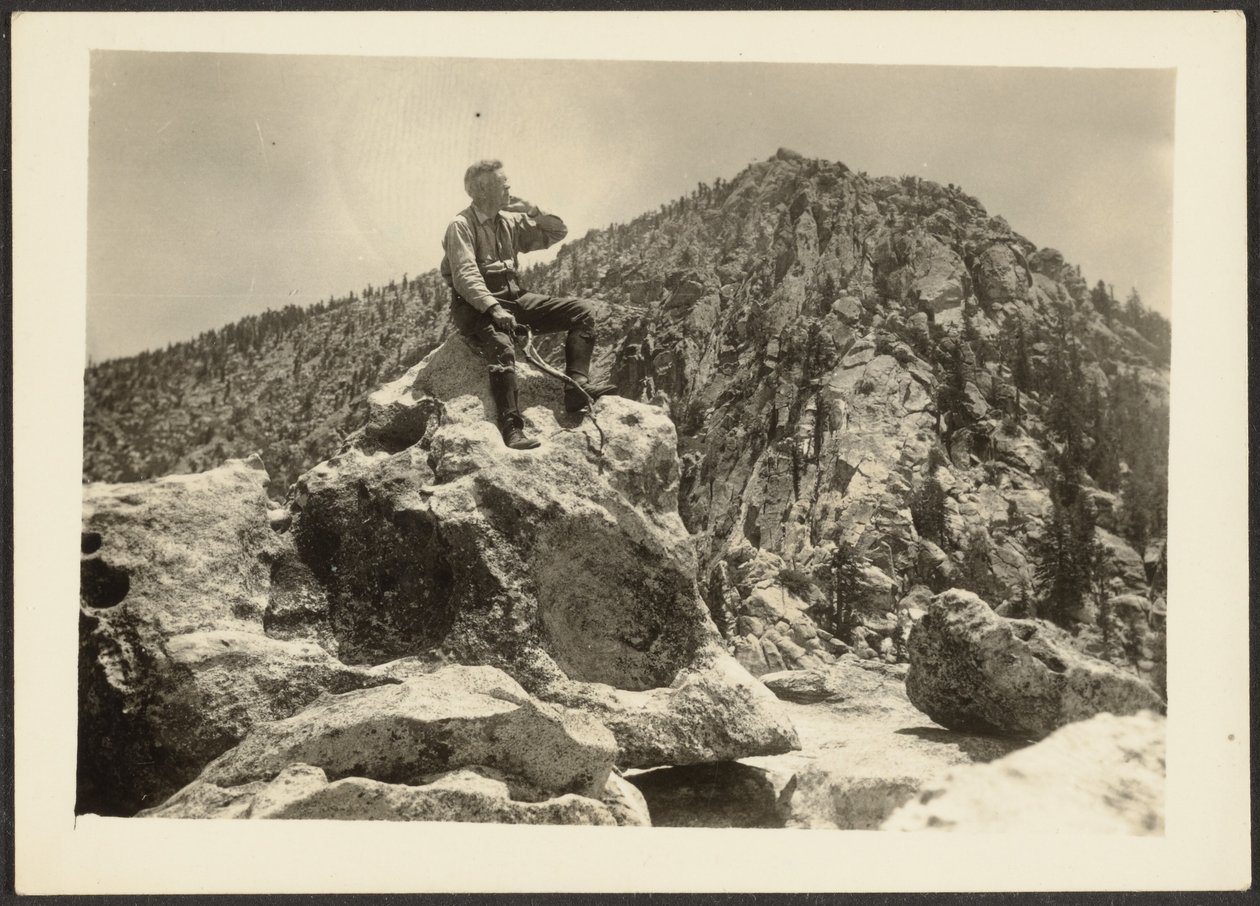 [Homem sentado em cima de rochas]. de Louis Fleckenstein