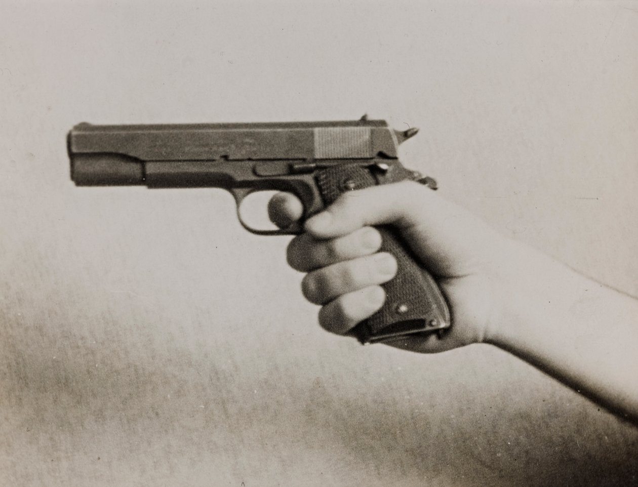 Uma mão a segurar uma pistola automática de Luigi Leoni