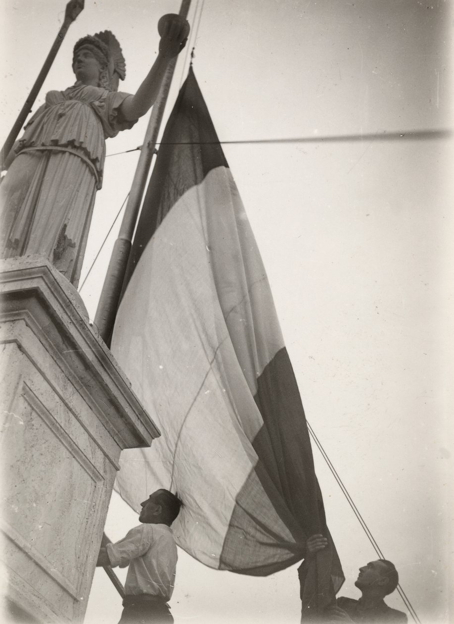 Bandeira italiana hasteada junto a uma estátua de Luigi Leoni