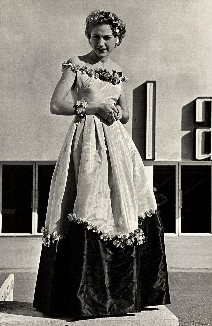 Modelo em vestido de baile criado pela casa de alta costura "Graldi". O artigo é caracterizado por uma linha de pescoço baixa e saia cheia decorada com apliques florais. (foto a p/b) de Luis Bogino