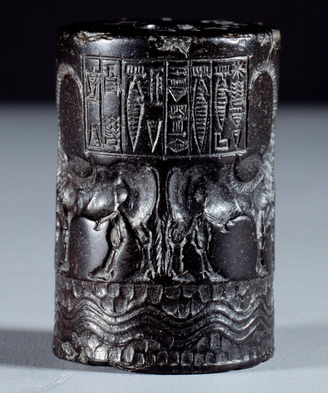 Mesopotâmia: selo cilíndrico em mármore preto em nome do divino Sharkali-Sharri (Shakalisharri), rei de Agade adorna com adornos de búfalos regadores de heros. 2300 AC. Paris, Museu do Louvre de Mesopotamian Mesopotamian