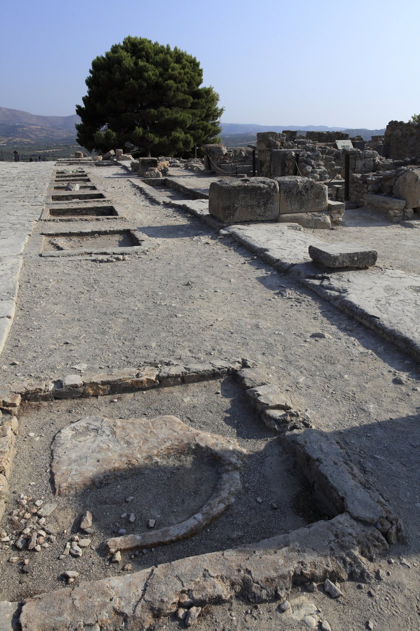 Sítio arqueológico minoano de Phaistos. Vista geral dos santuários da ala oeste ao longo da corte central a partir da ala norte. Havia dois tipos de santuários: "Santuário de Bancada" e "Bacia Lutral". O "Santuário de Bancada" era uma sala pequena e rectan de Minoan