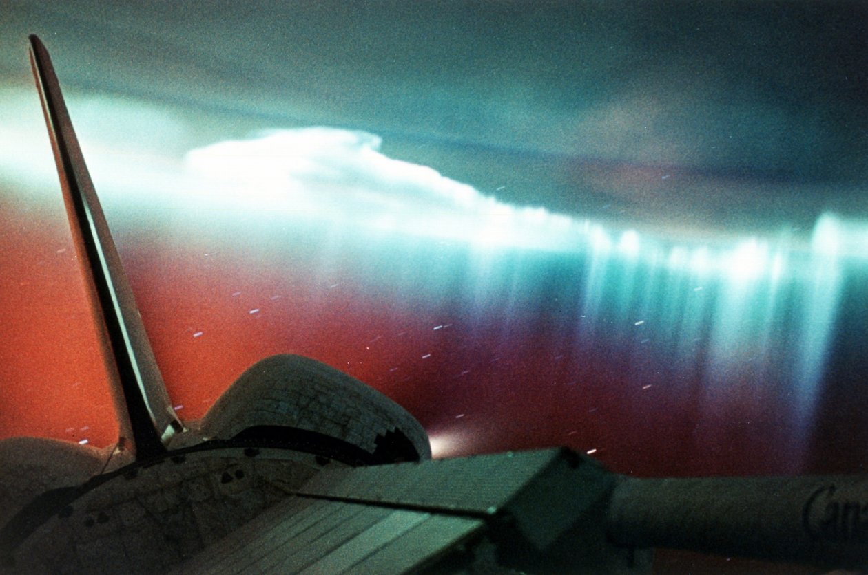 Aurora Australis (formulário da cortina) vista do esforço do vaivém espacial, parte de que pode ser visto no primeiro plano direito superior. Abril de 1994. Fotografia da NASA. de National Aeronautics and Space Administration National Aeronautics and Space Administration