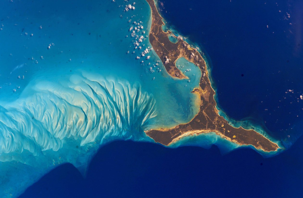 Ilha de Eleuthera, Bahamas, 2002. As formações submarinas a oeste da ilha são feitas de areia de carbonato de cálcio erodida a partir de recifes de coral e depositadas nas dunas pelas correntes oceânicas. Crédito NASA Ciência e de National Aeronautics and Space Administration National Aeronautics and Space Administration