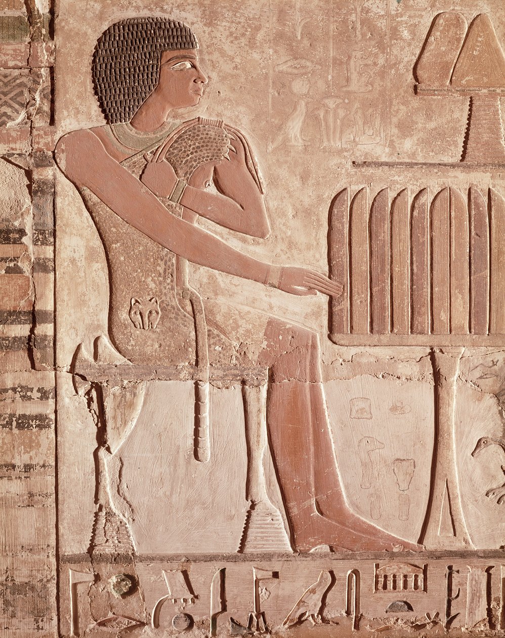 Relevo retratando o falecido sentado diante de uma mesa de oferendas com pão (pedra pintada) de Old Kingdom Egyptian