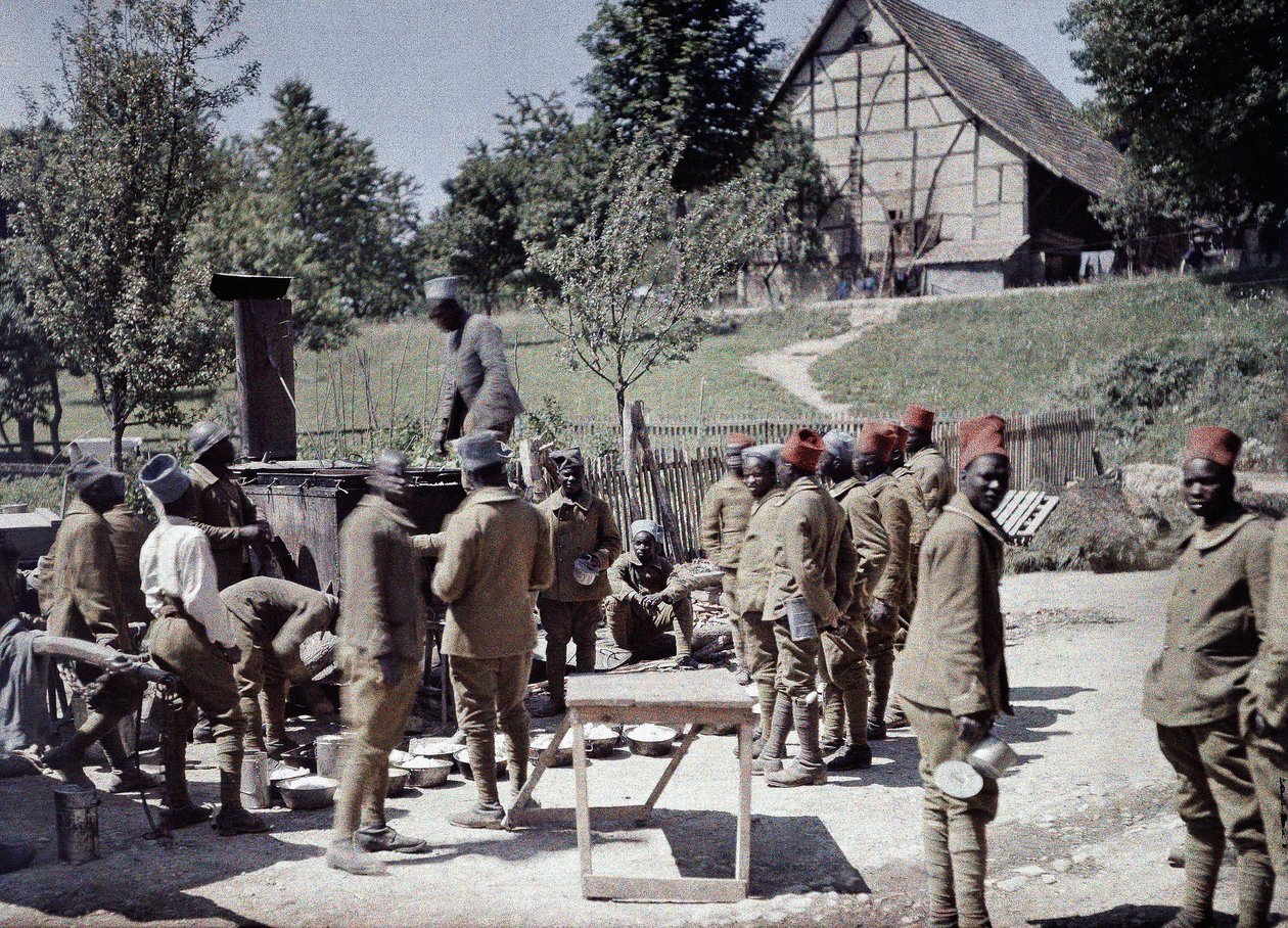Um grupo de soldados senegaleses servindo no exército francês como soldados de infantaria que almoçam em Saint-Ulrich, departamento Alto Reno, Alsácia, França, 16 de junho de 1917 (automático) de Paul Castelnau
