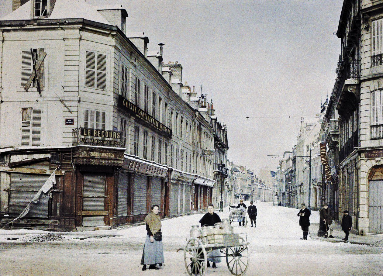 Uma mulher com uma carroça cheia de latas de leite na Rue de Vesle e um homem com outra carroça na Rue de Talleyrand atrás dela, Reims, França, 3 de março de 1917 (preto e branco) de Paul Castelnau