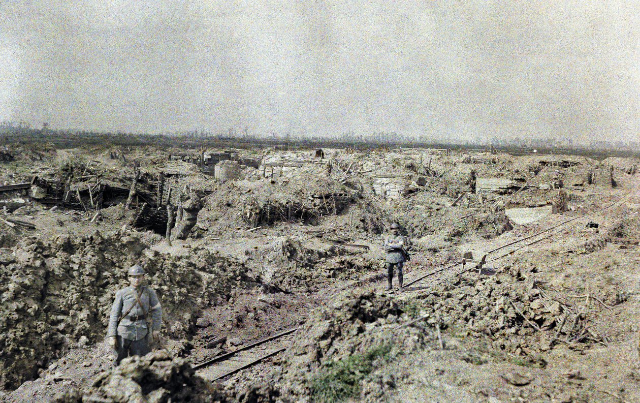 Dois soldados franceses em pé em uma ferrovia de bitola estreita perto da linha francesa em Het Sas em uma área que foi devastada pelo fogo de artilharia, Bélgica, 10 de setembro de 1917 (autocrômico) de Paul Castelnau