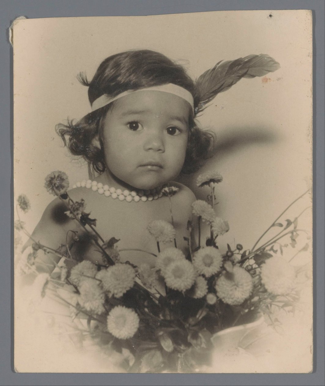 Retrato de uma criança desconhecida com uma faixa de cabeça e um ramo de flores de Paul Rollman