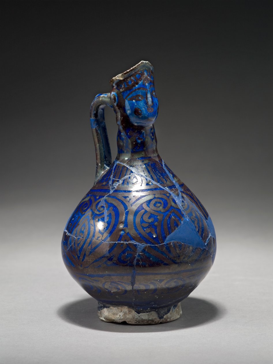 Jarro de cabeça humana, Irã, início do século XIV (pasta de pedra com brilho dourado sobre o esmalte azul) de Persian School
