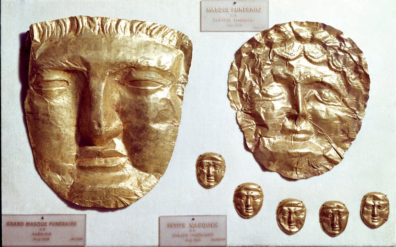 Arte fenícia: grandes máscaras de folhas de ouro no rosto da mulher e do homem e grupo de cinco pequenas máscaras de ouro no fundo de Phoenician Phoenician