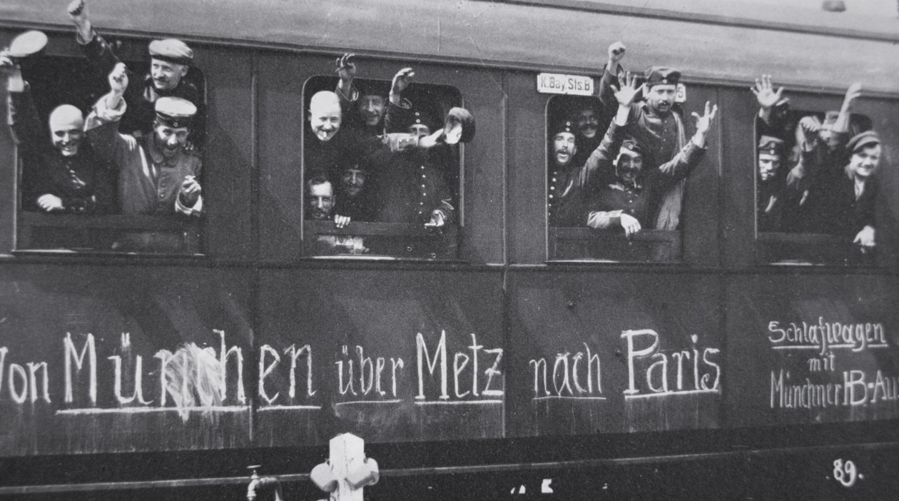 Tropas alemãs da Primeira Guerra Mundial partem para a frente de uma carruagem ferroviária com a mensagem "De Munique via Metz para Paris", Setembro de 1914 (foto a p/b) de Photographer German