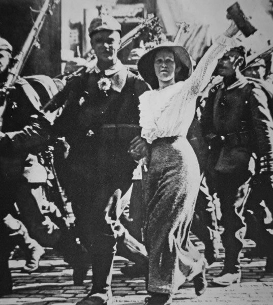 Tropas alemãs da I Guerra Mundial marchando para a guerra, suas túnicas e rifles enfeitados com flores da multidão jubilosa de Photographer German