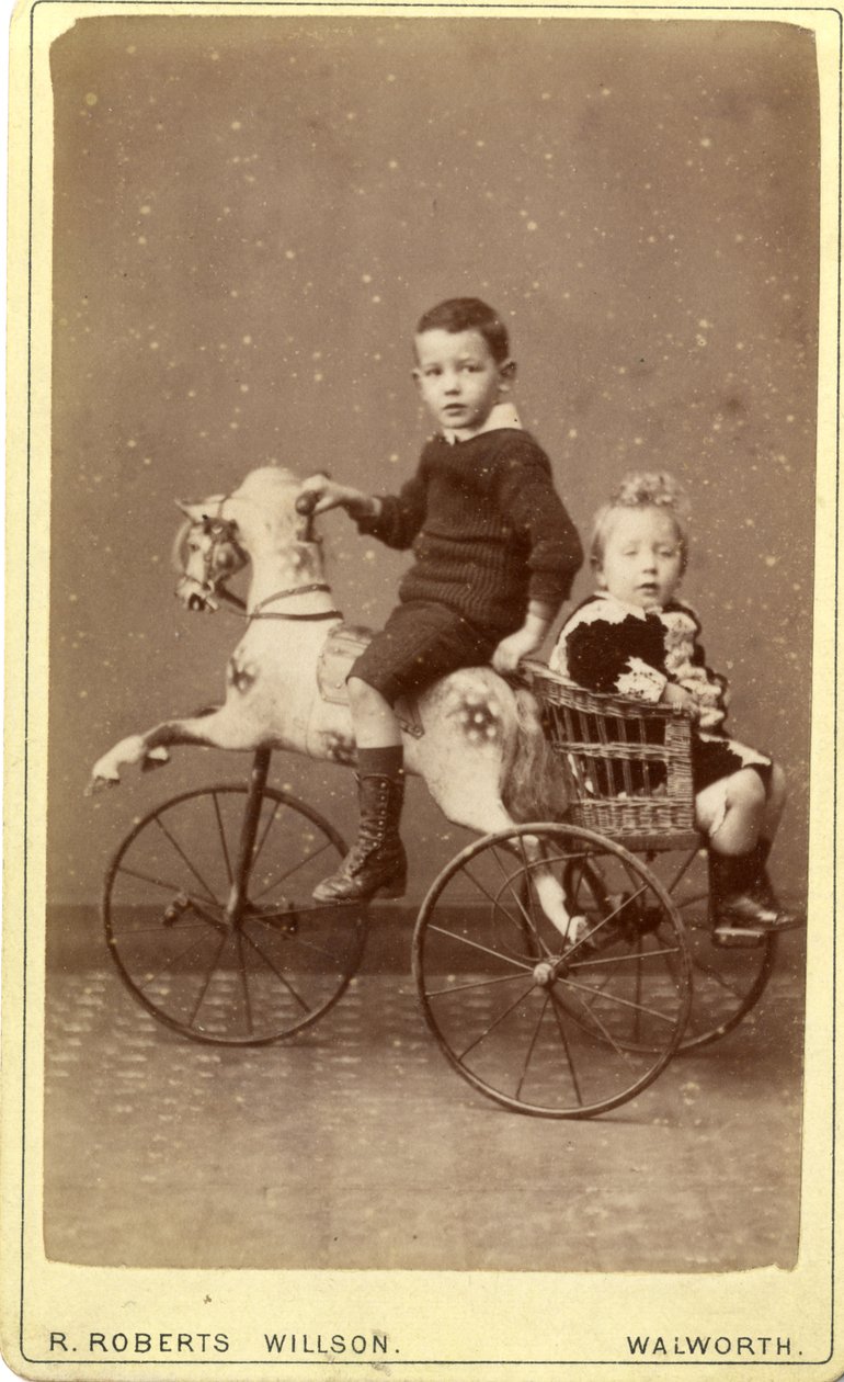 Menino jovem, ligado, cavalo balanço, com, menina jovem, em, carruagem vime, atrás de, 1880s, (albumen, impressão) de R. Roberts Willson