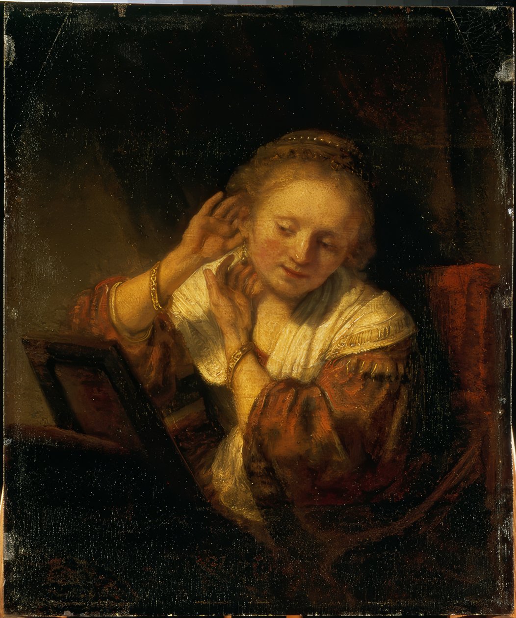 Jovem, decorando-se com brincos de Rembrandt van Rijn
