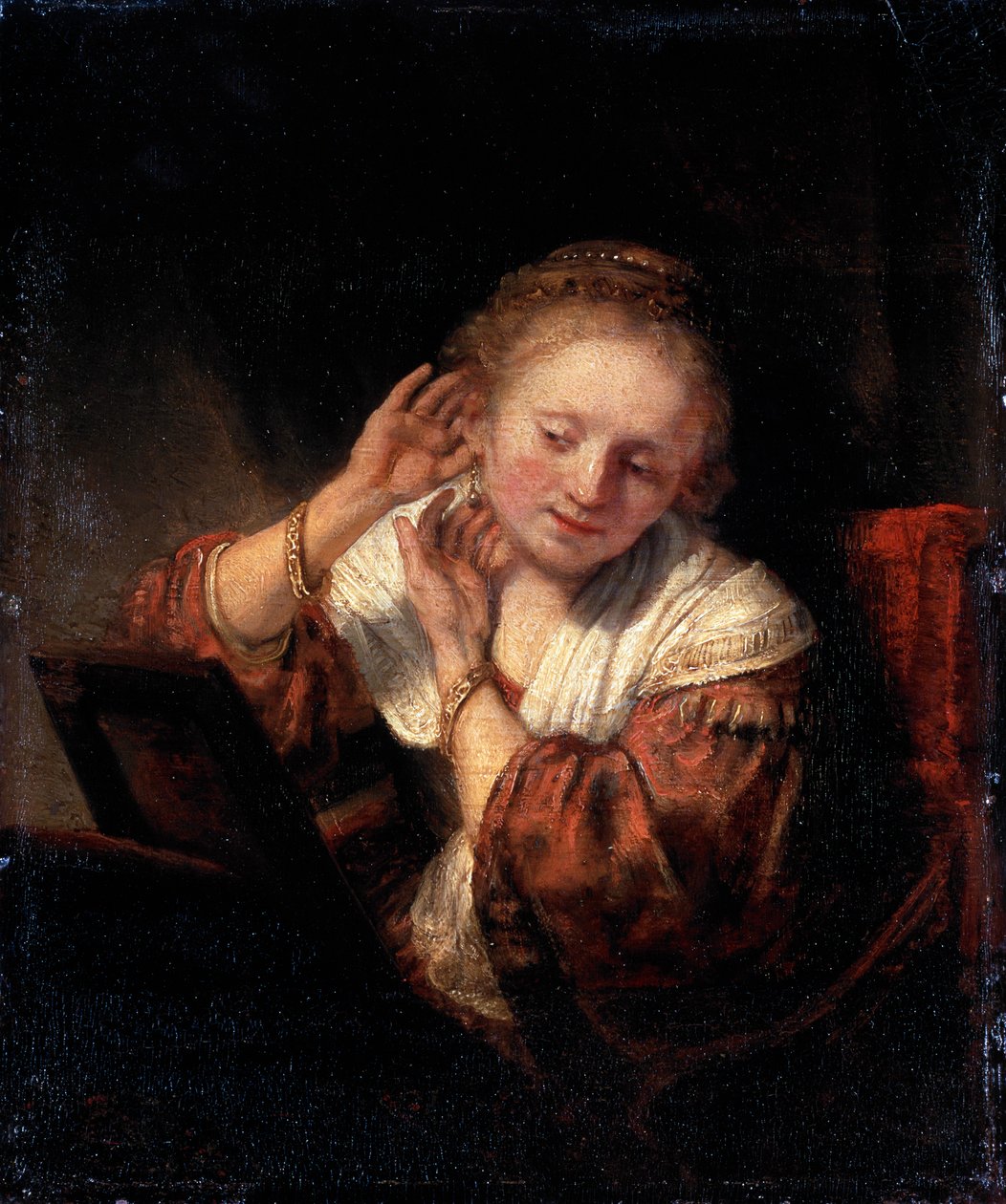 Jovem experimentando brincos, 1657. de Rembrandt van Rijn