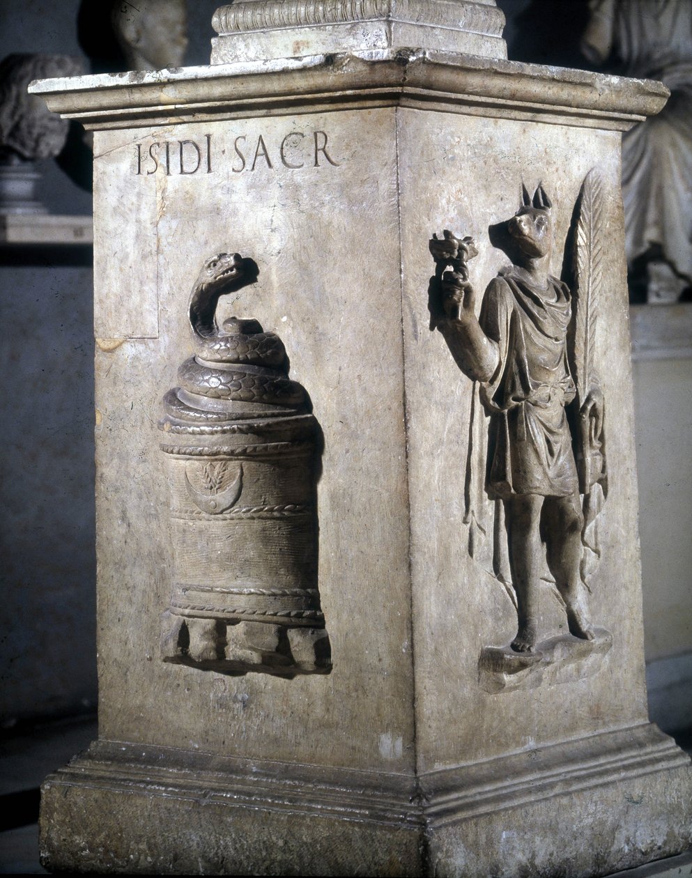 Altar dedicado a Ísis. Esquerda: pedra mística com serpente e direita: Anubis-Hermès. As palavras "Iside Sacr" estão gravadas na serpente. Século II. Musei Capitolini, Roma. de Roman