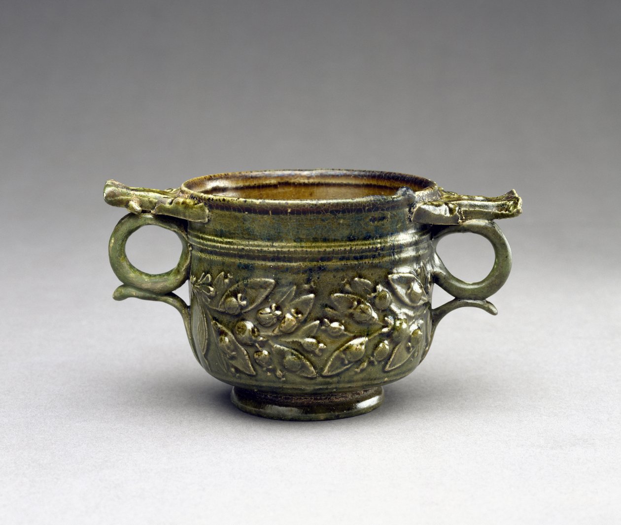 Skyphos esmaltado verde com alças levantadas, molduras de folha e baga, AD 1-100 (terracota) de Roman