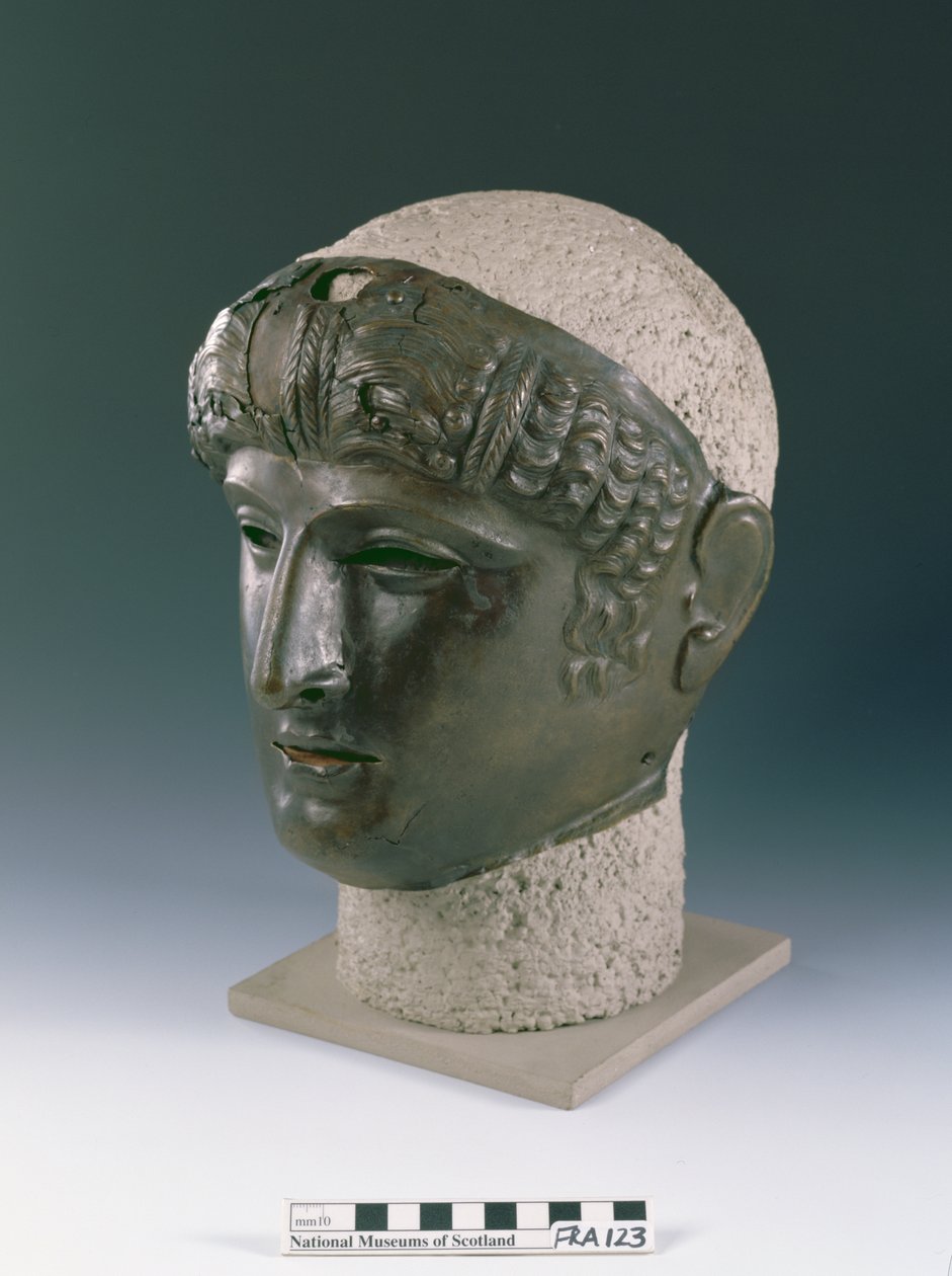 Máscara de desfile de um rosto jovem masculino, do sítio romano em Newstead, Melrose, final do século I d.C. (bronze) de Roman