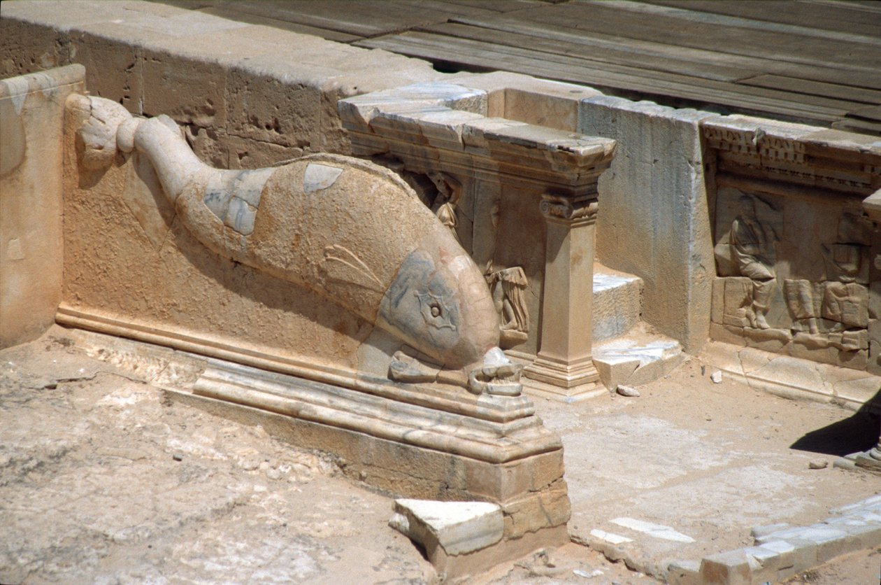 Escultura em relevo de um golfinho em frente ao palco do Teatro Romano (foto) de Roman