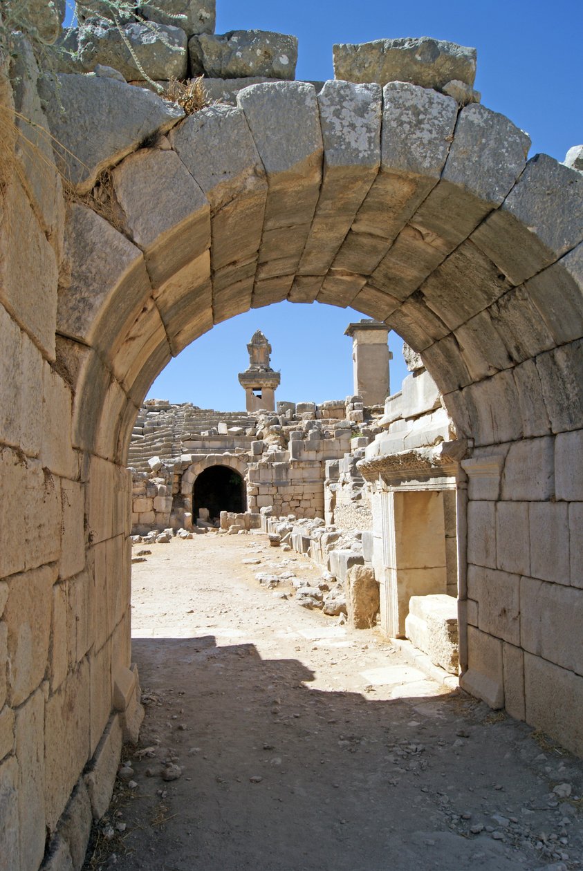 Vista através da entrada abobadada do teatro Xanthos no fosso da Orquestra, mostrando pilar e túmulo de Harpia, Xanthos, Turquia (foto) de Roman