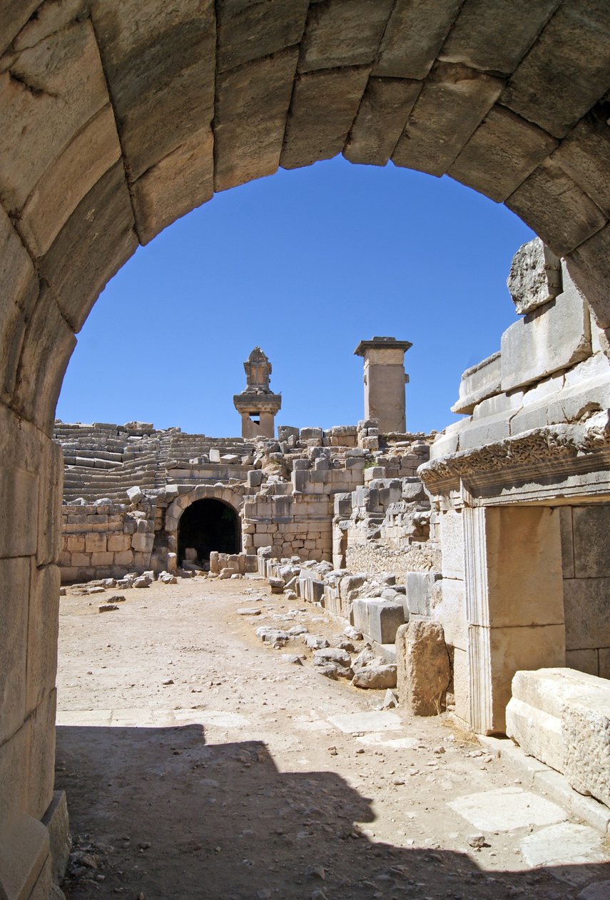 Vista através da entrada abobadada do teatro Xanthos no fosso da Orquestra, mostrando pilar e túmulo de Harpia, Xanthos, Turquia (foto) de Roman