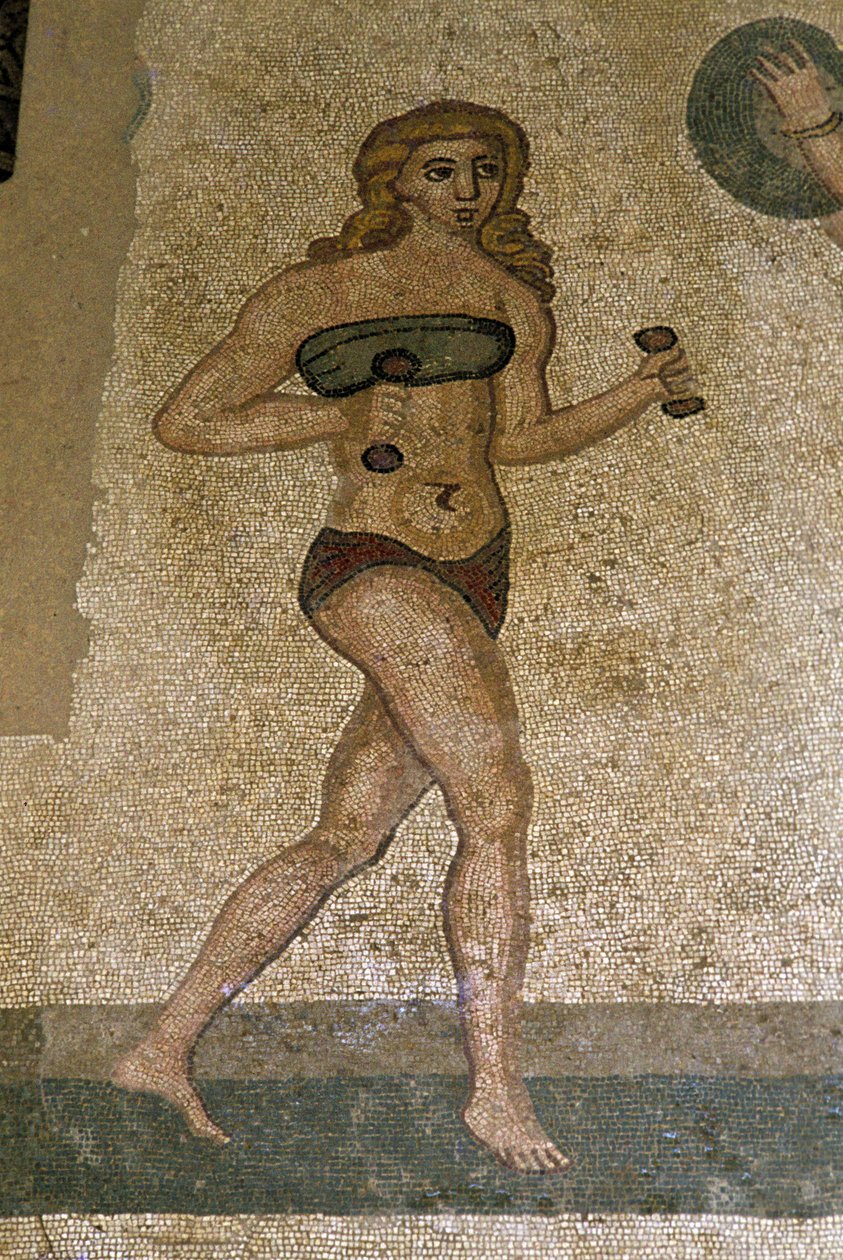 Jovens romanos envolvidos em exercícios físicos. Eles usam uma tanga ao redor dos rins e um estrofio (ancetra do sutiã) no peito. Uma tanga à volta dos rins. Mosaico romano do século III - IV de Villa del Casale, Piazza Armerina (Sicília). de Roman
