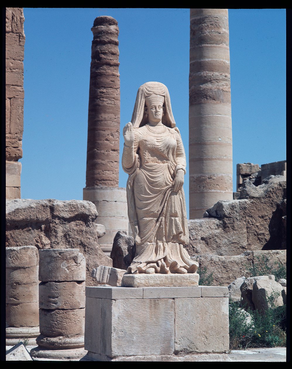 Ruínas com uma estátua de Abu Bint Damion (Século I d.C.) de Roman Roman