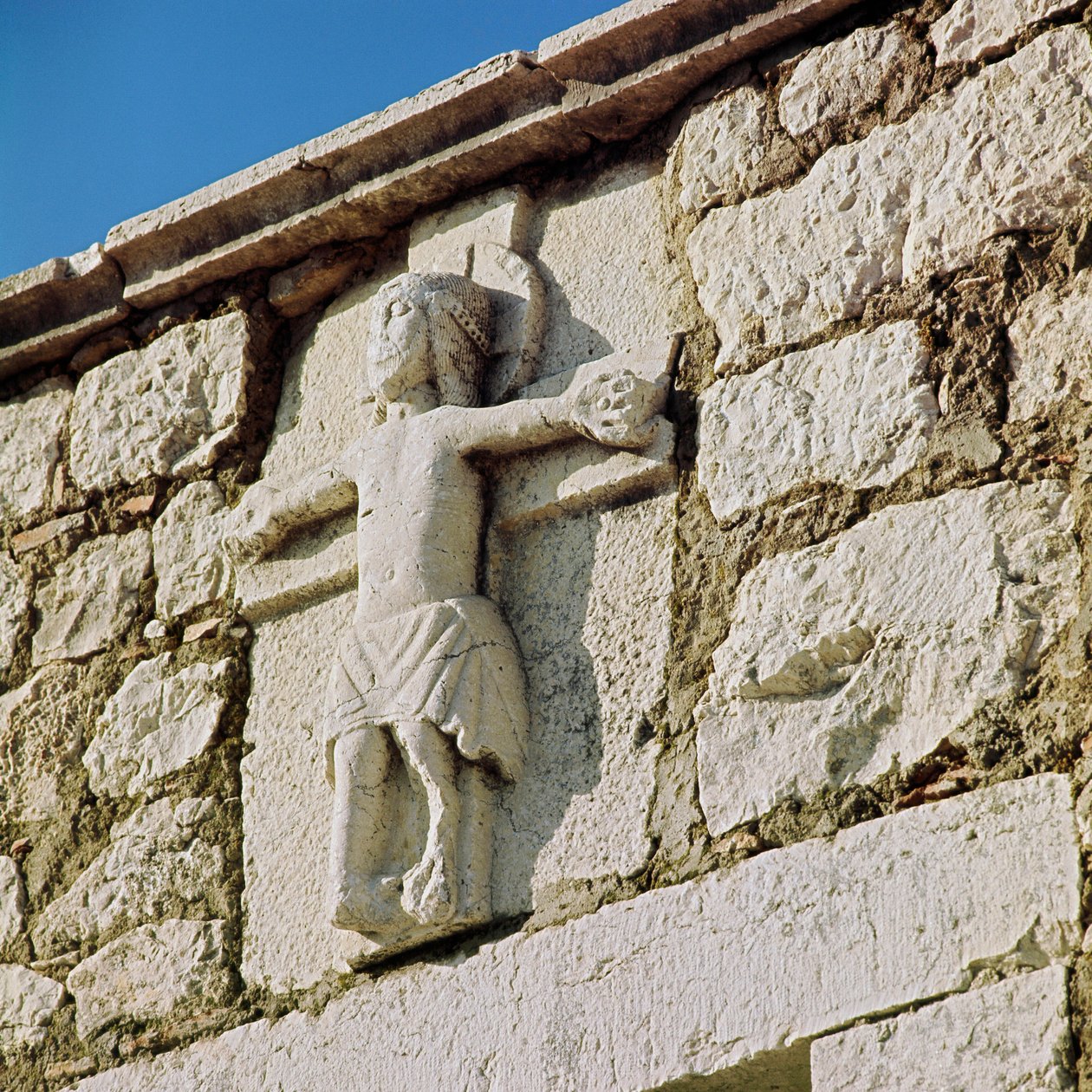 Cristo crucifica a escultura de pedra do século XIII. Portal da Igreja Românica de San Bartolomeo, Campobasso Itália de Romanesque