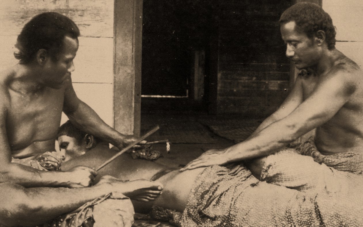 Um homem samoano sendo tatuado, c.1895 sépia foto de Samoan
