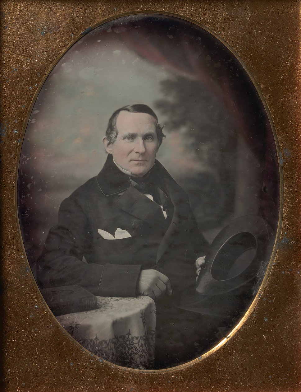 Homem vestindo casaco e luvas, segurando o chapéu, sentado na frente do pano de fundo pintado ao ar livre, década de 1840. de Samuel Broadbent Jr..