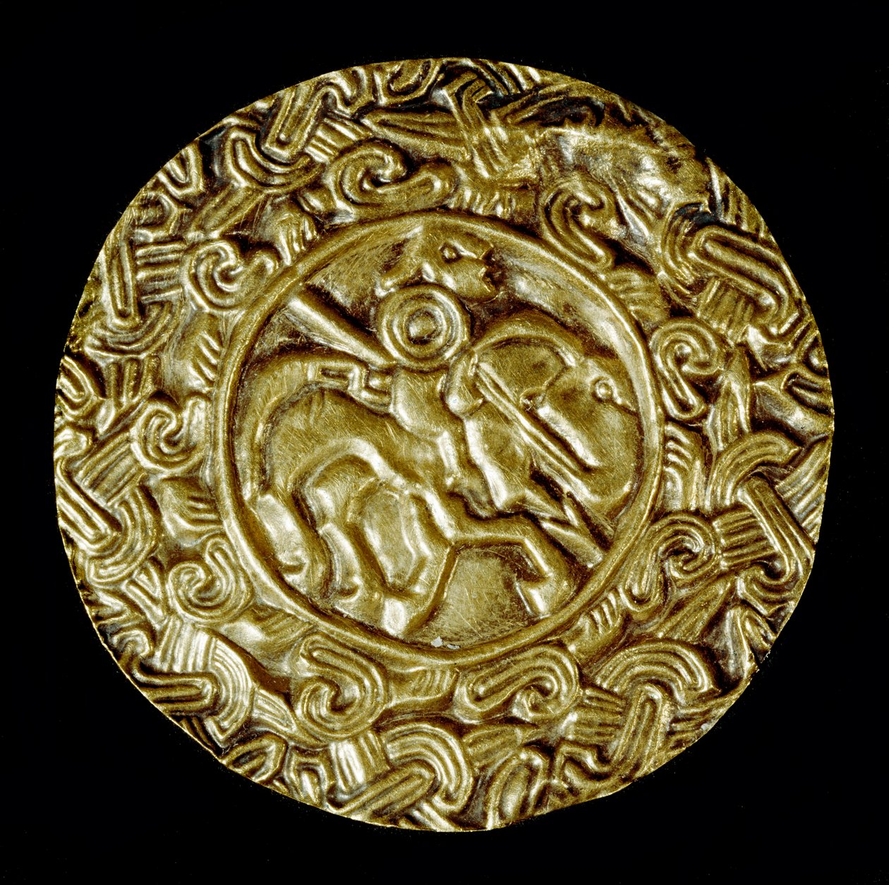 Arqueologia da Idade Média (Idade Média). Arte bárbara da Lombardia: disco de ouro. No centro está um santo a cavalo com uma lança e ao redor de motivos animais. Arte lombarda, em torno de 600. Dim: 47 cm Itália, Cividale del Friuli, Museu Arqueológico. de School Lombard