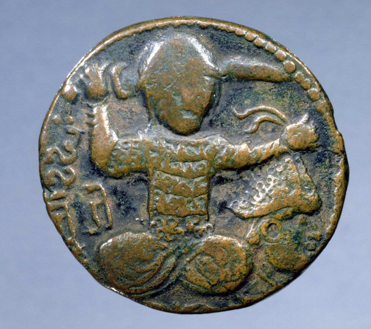 Anverso de moeda (bronze) representando o turco sentado de pernas cruzadas segurando uma espada atrás da cabeça na mão direita e uma cabeça cortada na mão esquerda. cunhado por Husam al-Din Yuluq Arslan (1184-1201) de School Turkish