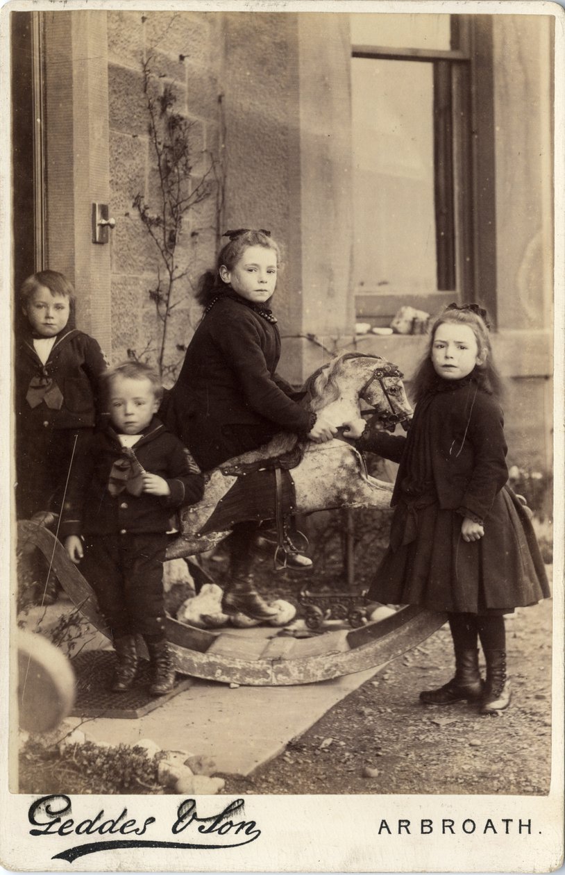 Grupo de crianças pequenas e o seu cavalo de balanço de Scottish Photographer