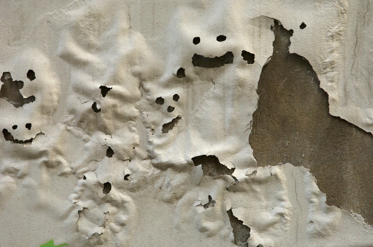 Itália, Toscana, Florença, Rostos sorridentes de fantasmas numa parede pintada pelo tempo, 2022 (foto) de Sisse Brimberg