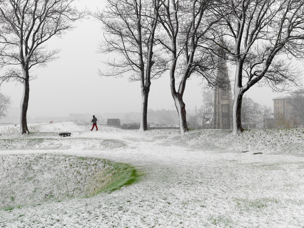 Figura solitária a caminhar na Fortaleza de Copenhaga durante uma tempestade de neve, Dinamarca, 2022 (foto) de Sisse Brimberg