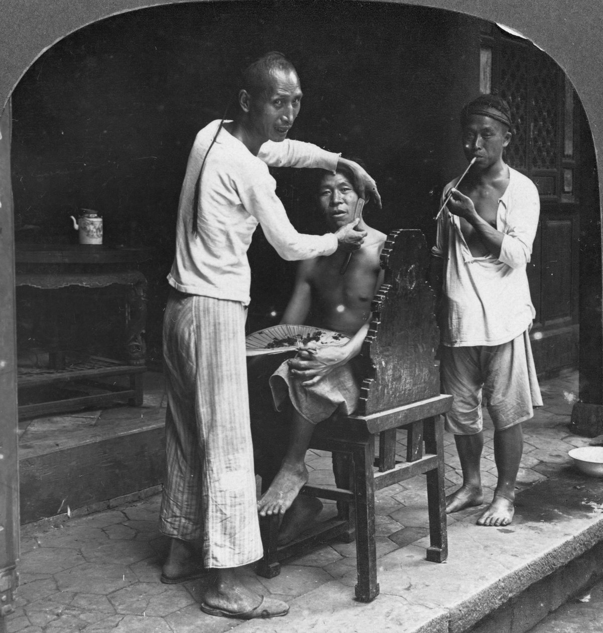 Um barbeiro chinês em Bhamo, Birmânia, 1908 de Stereo Travel Co