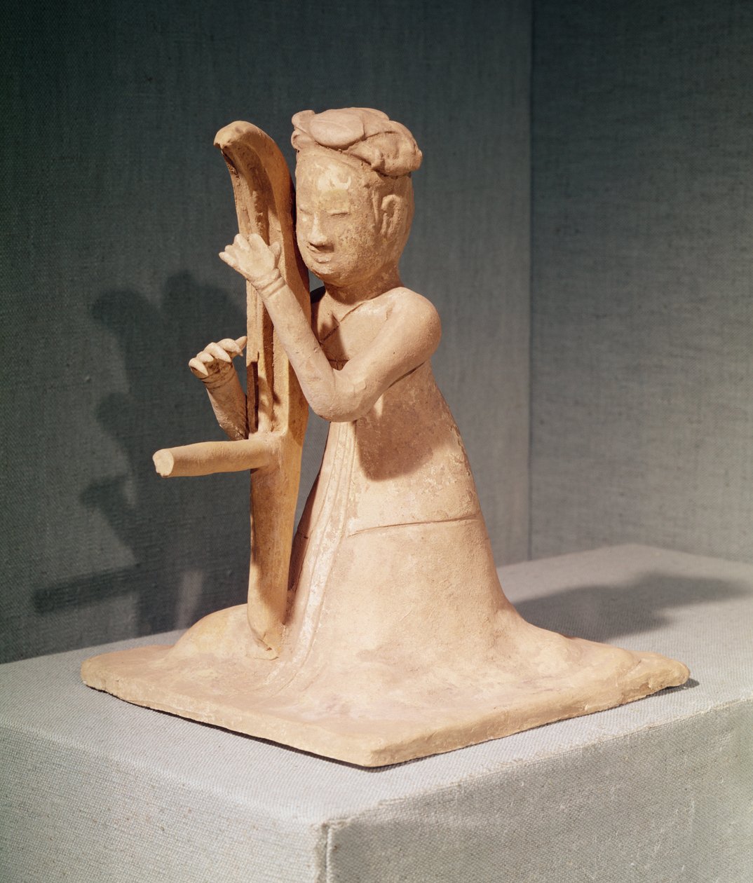Músico sentado tocando uma harpa (terracota pintada) de Sui Dynasty Chinese School