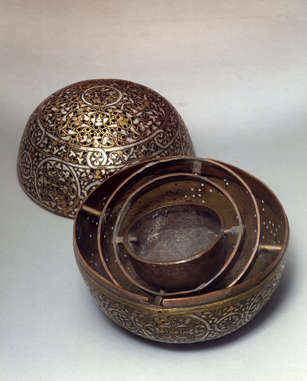 Arte Oriental: Perfume Burle (queima-perfumos) ou aquecedor de mãos da Síria, final do século XV, início do século XVI. Liga de cobre martelada com decoração grave, pierces, incrustada com ouro, prata e pasta preta. Paris, Musee Du Louvre de Syrian School