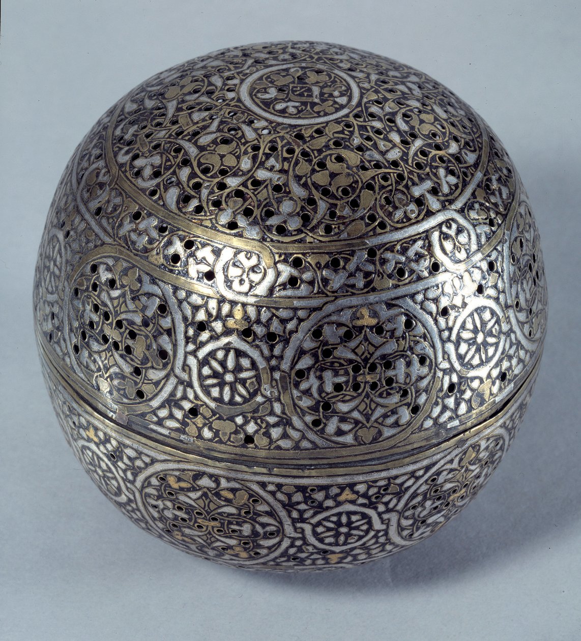 Arte Oriental: Perfume frutado (queima-perfume) ou aquecedor de mãos da Síria, final do século XV, início do século XVI. Liga de cobre martelada com decoração grave, pierces, incrustada com ouro, prata e pasta preta. Paris, Musee Du Louvre de Syrian School