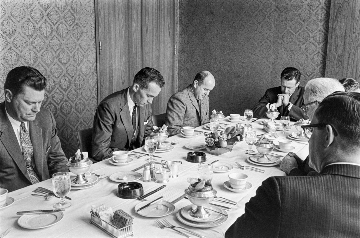 Homens de negócios rezam antes de começarem a almoçar numa reunião de angariação de fundos da igreja de Ted Spiegel