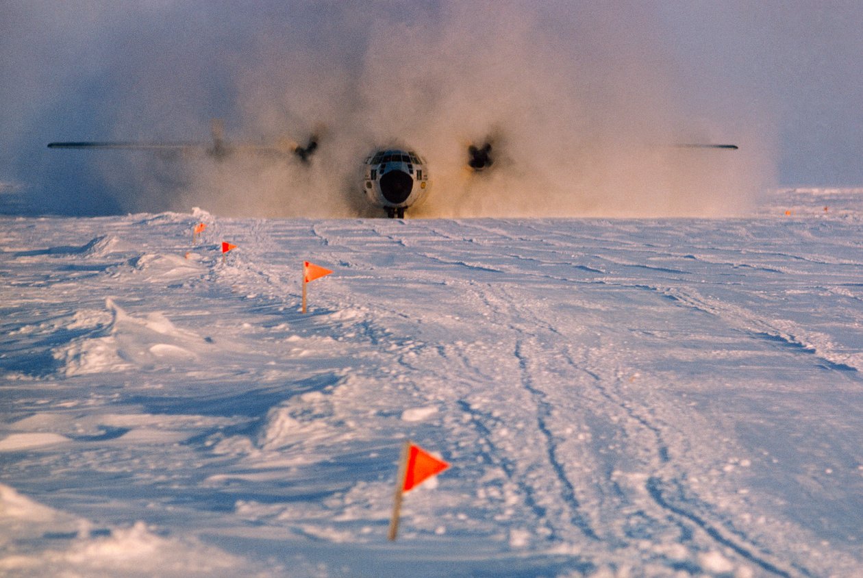 Obscurecido pelo fumo, o avião de abastecimento aterra na pista de aterragem de Arlis II. de Ted Spiegel