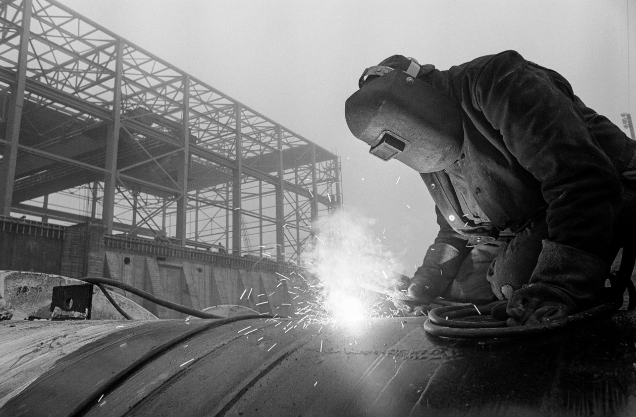 Soldador utiliza maçarico de acetileno para soldar tubos industriais em estaleiro de construção em Hanfor... de Ted Spiegel