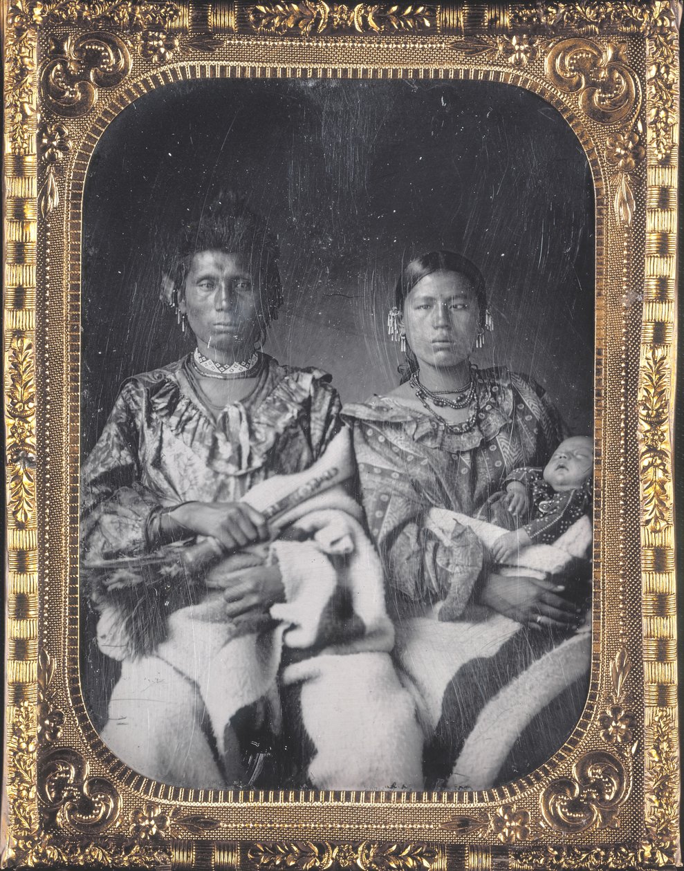 Retrato de Mahee (faca) com sua esposa Kunzanya e filho do Iowa. Eles usam jóias frisadas e cobertores grossos. Mahee tem um objeto na mão de Thomas M. Easterly